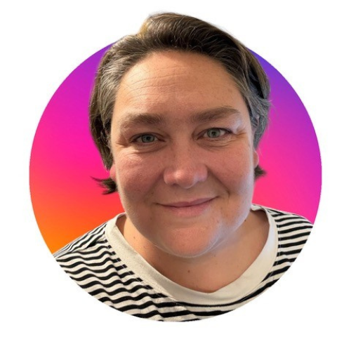 An image of a person with short brown hair wearing a black and white striped top. Their head and shoulders are visible against a pink, round background.